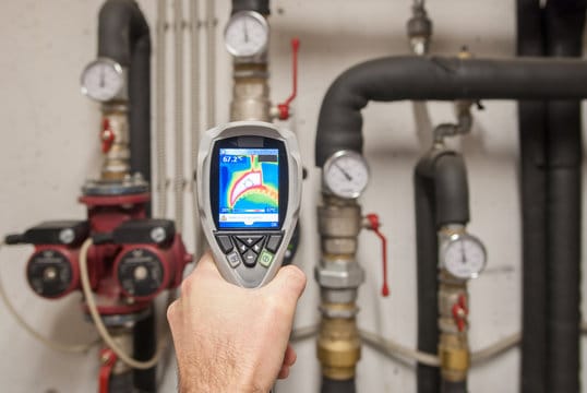 Plumber using a thermal imaging camera to inspect pipes in Littleton